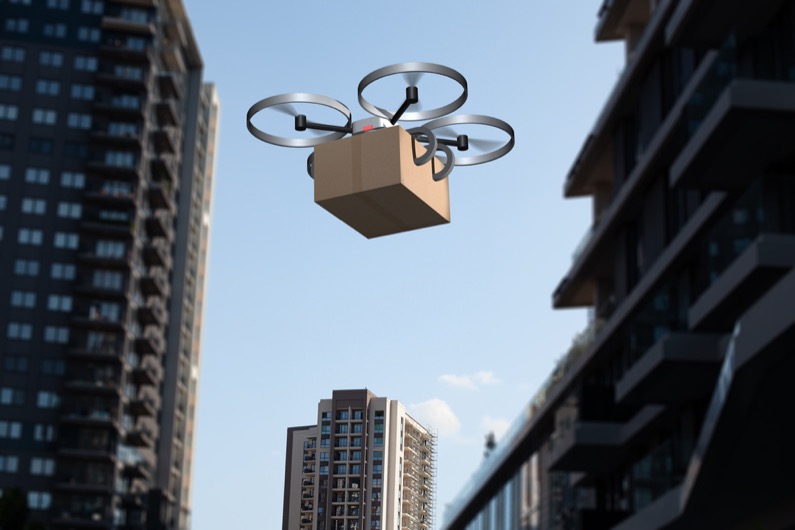 delivery drone carrying a package flying above the city
